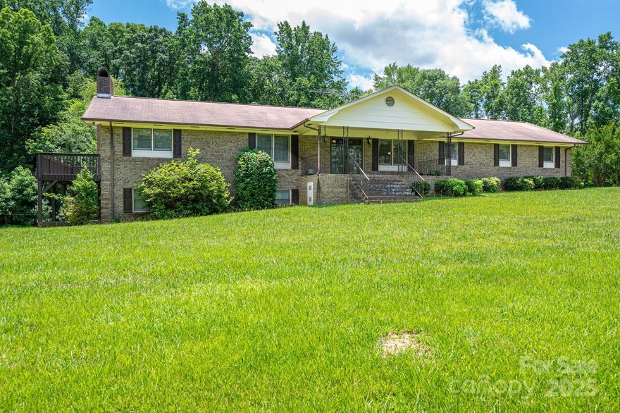 Tucked away on 12 private acres in the Lake Wylie community—where large tracts of land are rare—this brick ranch is a unique retreat for those craving space, privacy, and versatility. Whether you're dreaming of a mini-farm, equestrian setup, or simply want room to roam, this property delivers. Inside, you'll find a warm, welcoming layout with a cozy living room and spacious kitchen that boasts a large eat-at island and ample cabinet storage. Start your mornings in the sunroom, complete with a ceiling fan and lovely views. The primary suite features a sliding door to a private deck and a private ensuite bath. The finished basement offers a second living space, full kitchen, extra bedroom, and endless possibilities with the large storage area. A detached workshop adds functionality, while a creek meanders along the wood-line, enhancing the natural charm. This home is ideal for hobby farmers, horse lovers, or anyone looking to escape the bustle without sacrificing convenience.
