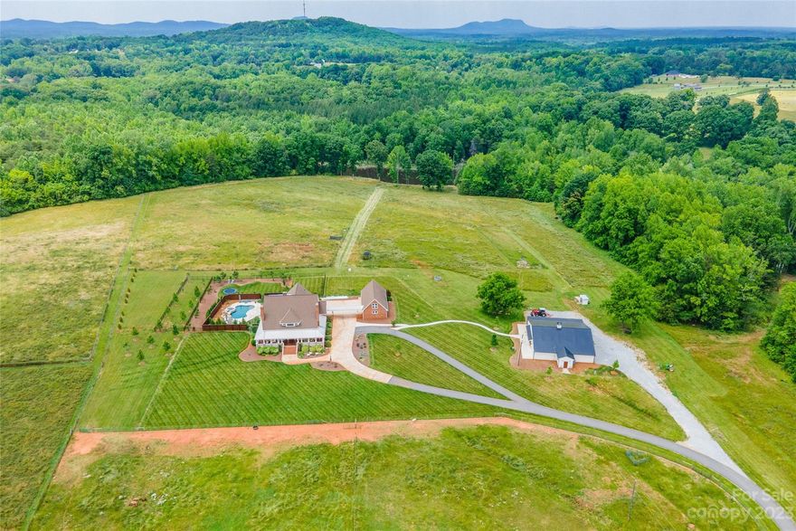 Ready to move in and bring the horses! Incredible opportunity to own a farmhouse with too many features to name. Beautifully designed with a welcoming wrap around porch. Great entertaining home offers dramatic ceilings with exposed woods beams and southern charm. The gourmet kitchen is quite impressive and has all the bells and whistles! The resort-like outdoor oasis features an in-ground gunite pool (heated) with grotto, gorgeous fireplace & travertine tile patio is covered with built in heaters which is the perfect spot for all four seasons. Outdoor play time made complete with an in-ground trampoline! Stocked pond for fishing. 55x55 Barn is wired with 4 stalls, two separate restrooms & has great potential for hosting events or weddings.Recent updates: Travertine tile, upgraded HVAC, patio extension, metal roofing, closed cell foam insulation in barn walls/ceiling, additional 2 stall barn. This home is ready for its new owners. Includes Tract B&C Adjoining properties.