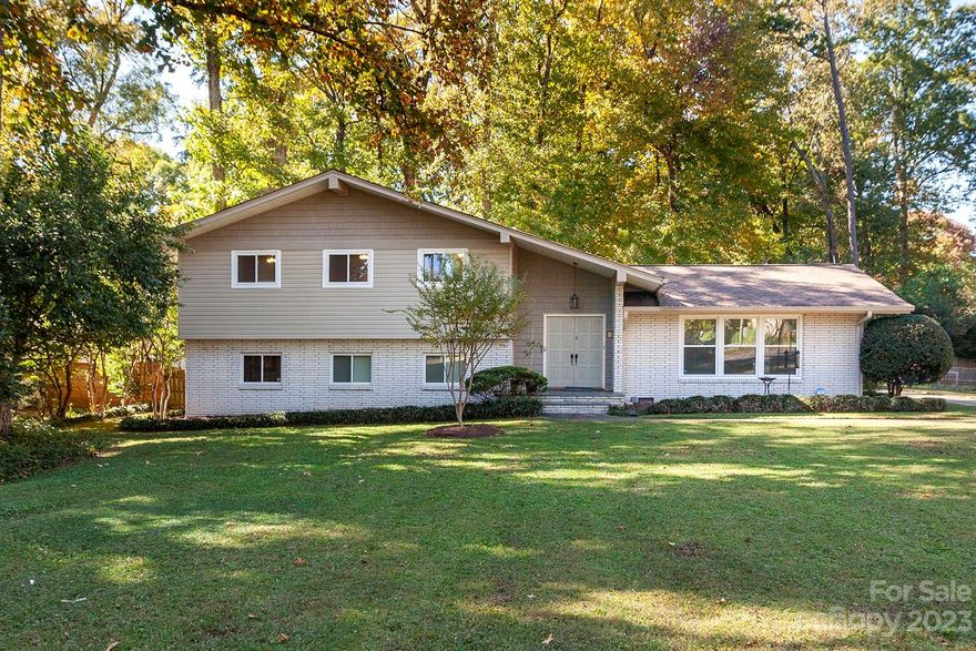 Classic Mid-Century Modern Gem located in Sherwood Forest. Experience modern living in this 3-bed, 3-bath home offering tasteful updates with authentic mid-century style. This residence features a perfect blend of comfort and character. Nestled in a tranquil Charlotte suburb, it provides easy access to all the area's amenities. Enter the double front doors to a wood-beamed ceiling and original design details. The sunken living room offers a built in bar and full brick fireplace wall. Step outside to a spacious patio with a cozy fire pit, perfect for gatherings. You'll have the ability to work seamlessly from home in the dedicated office space, a haven for productivity. Don't miss the well-equipped workshop that is ready for your creative endeavors. The beautifully manicured lawn and peaceful back yard add an inviting touch to this timeless property. This residence embodies a balanced blend of original mid-century elements and contemporary functionality, awaiting your personal touch.