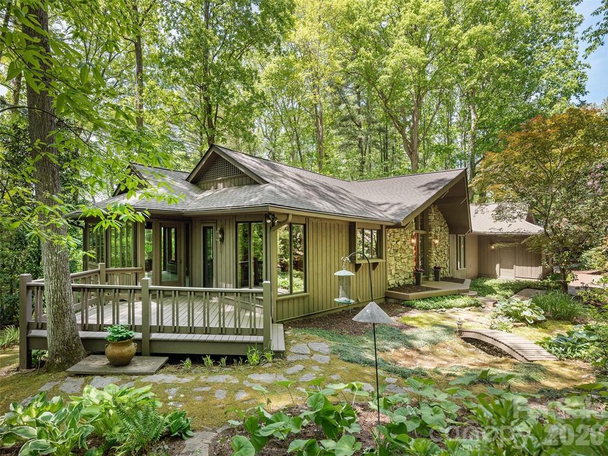 Tucked beneath a canopy of mature trees in coveted Chanteloup Country Estates, this beautiful Flat Rock residence offers a blend of refined comfort and serene privacy but is just 5 minutes from the charm and culture of Hendersonville. From the moment you arrive, the home’s exterior and lush surroundings set a tone of understated sophistication. Inside, vaulted ceilings soar above the Great Room, where natural light filters through the trees, creating a warm and inviting ambiance. The thoughtfully designed main level flows effortlessly—from the Great Room to a separate dining room and on to a year-round sunroom. The kitchen is both stylish and functional, ideal for preparing intimate dinners or hosting lively gatherings. The lower level features a cozy family room anchored by a wood-burning fireplace, two additional bedrooms for guests or family, and generous storage space. Outdoors, enjoy the beautifully landscaped grounds, a spacious deck, and a tranquil patio. This home has a new roof, new carpet and has been repainted inside and out. And perhaps best of all, it's priced below current appraised value.