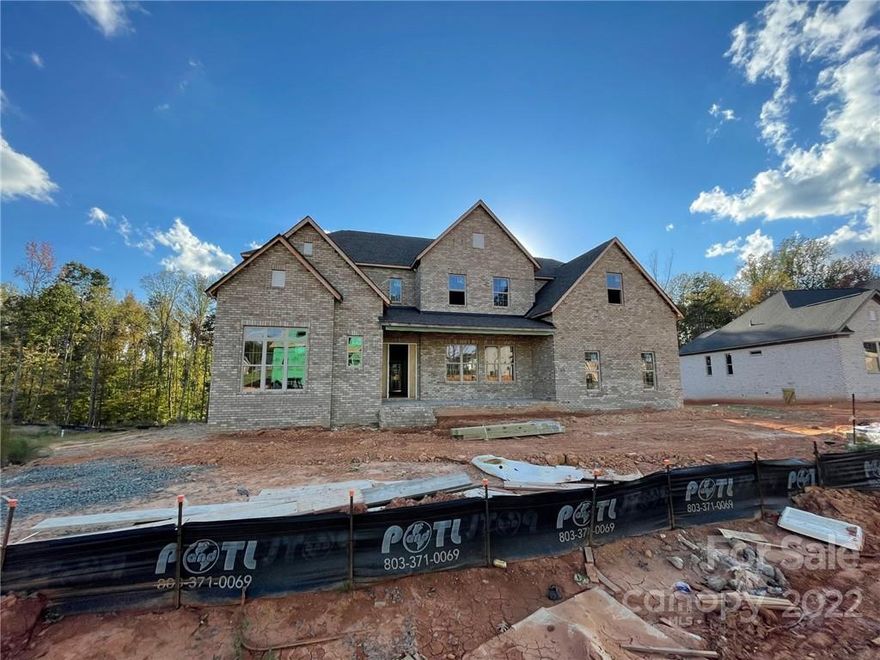 Located near Marvin and Blakeney, this home backs up to trees and common space for privacy. The exterior will be painted grey brick. 2-story grand foyer with large Dining room just off of it. First floor has a large guest suite with wet bar cabinets. Functional hobby/office space on the first floor. Morning room has gas fireplace plus large sliding doors leading outside. Rear covered patio is raised and features an outdoor fireplace. Kitchen has painted cabinets. Large bonus room upstairs. Full bath for every bedroom. Many built-ins and luxury finishes throughout. Great amenities include pool, playground, and gathering house.