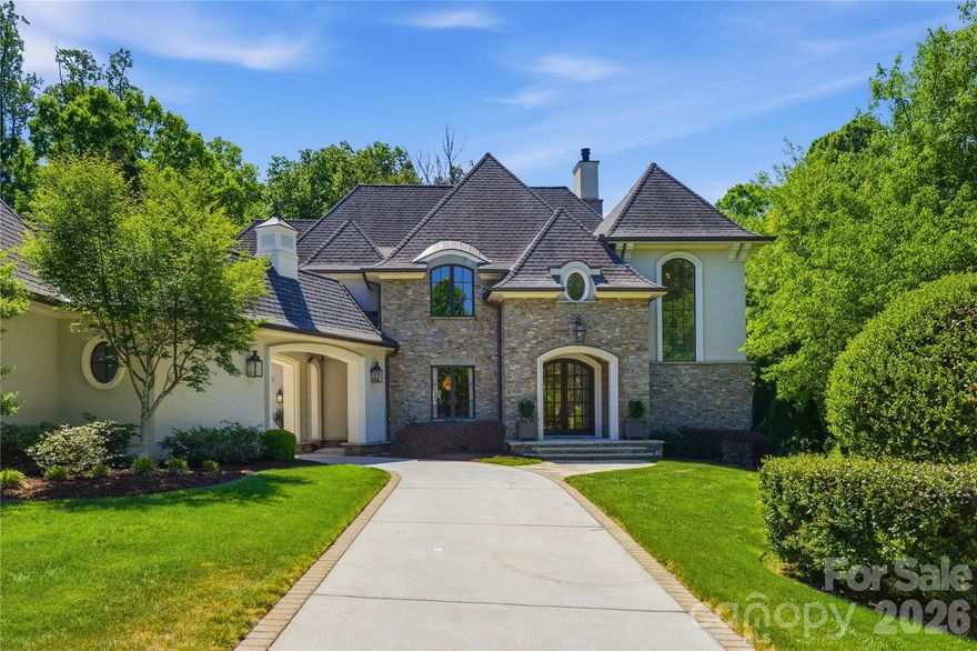 Situated in the prestigious heart of SouthPark, this architectural masterpiece by Gerrard Builders represents a flawless collaboration between designers Christopher Phelps and Shannon Bowman Interiors. The estate makes a commanding first impression with a timeless stone and stucco facade, punctuated by a striking porte-cochère that elegantly connects the main residence to a private third-car garage. Upon crossing the threshold, the soaring two-story foyer serves as a prelude to the home’s interior grandeur, featuring a sculptural open staircase with two-story windows and topped with artisan wood-grained moldings. Hand-scraped hardwood floors anchor the main level, providing a warm and unique appearance for an award-winning floor plan. 
The culinary center of the home is a show-stopping chef’s kitchen, outfitted with top-tier luxury appliances, an expansive center island, and a discreet walk-in pantry. This space flows effortlessly into a luminous breakfast room and a grand family room, where cabinetry flanks a stately fireplace and a wall of windows overlooks a covered stone loggia, complete with a secondary fireplace and grilling station. 
For formal occasions, the light-filled dining room connects via a butler’s pantry to the kitchen and wet bar. Tucked away in the back of the main living space, beyond the kitchen and breakfast room is a beautiful den which also serves as the perfect reading nook.  This room features its own full bathroom with direct garden access and is the perfect transition from the home to a future pool. To make life easy there is a large drop zone with desk space and walls of lockers and added cabinetry connected to the 2 car garage entry. Laundry room on the first floor with 2nd refrigerator, built-in ironing station and utility sink.
All bedrooms in the home are ensuite. Guest bedroom on the main floor is ensuite with a large bathroom and closet.
On the upper level is an sanctuary of pure refinement. The primary suite is a sprawling wing unto itself, boasting a spa-inspired bathroom with free standing soaking tub, a seamless glass shower, and dual walk-in dressing rooms. This floor also hosts three additional generous guest ensuite bedrooms with large walk-in closets, a versatile bonus room with a custom wet bar, beverage fridge and a professional-grade home gym finished with performance cork flooring and floor-to-ceiling mirrors. 
Completing this home is a beautiful, serene, and fenced in back yard full of grass and trees that provide shade and privacy for entertainment; all located just moments from the world-class shopping and dining of SouthPark.