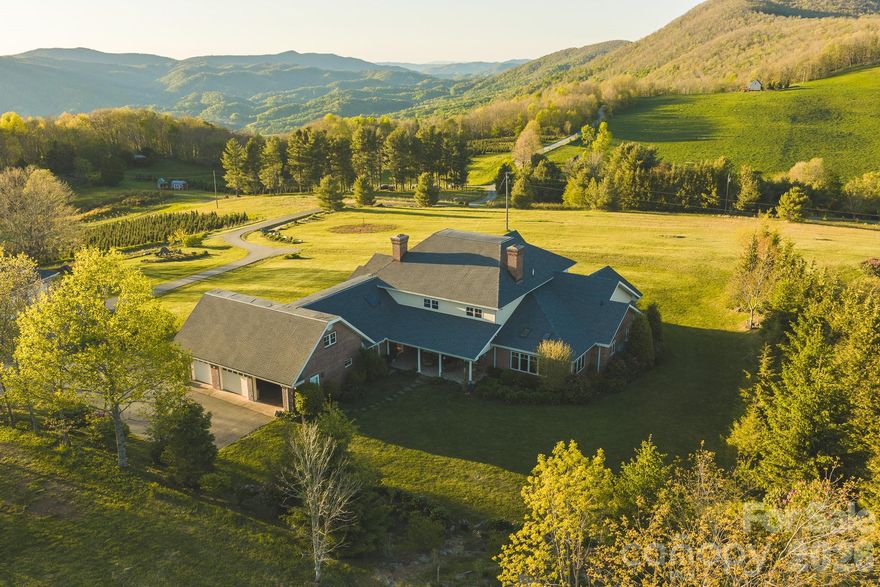 For sale by Online Auction with Reserve.  Price listed is starting bid only and not final sales price.
Situated at over 4,000 feet elevation, this stunning home offers long-range mountain views across the High Country from a +/-6.955 acre setting of open, gently rolling pasture. With no HOA and unrestricted use, this property offers flexibility rarely found in the Boone market. This 4-bedroom, 5.5-bath home offers over 7,500 square feet of above ground heated living space designed for large-scale mountain living, multigenerational use, entertaining, or a private retreat.  New roof installed 2025!

 Inside, the home features custom maple craftsmanship throughout, including flooring, trim, cabinetry, built-ins, crown molding, and detailed woodwork. The spacious kitchen with a central island anchors multiple living and gathering spaces, while 3 fireplaces add warmth throughout the home. The primary suite includes a walk-in closet and an attached office. Multiple bonus rooms and additional office spaces provide flexibility for remote work, guest accommodations, hobbies, or expanded living needs. A standout feature is the expansive lower level, offering optimal storage capacity, recreation space, and additional utility options. Entire basement area is heated, but not included as finished living space.

Additional property highlights include:

6 garage spaces total (attached 3-car garage + detached 3-car garage)
Detached garage with its own kitchen and bath
Multiple covered decks and patios positioned to capture the mountain views
Fiber optic internet availability
Stainless steel appliances
Tankless gas water heater
Central vacuum system
Two propane HVAC systems
Brick exterior for low-maintenance ownership

Located just minutes from Downtown Boone and Appalachian State University, this property combines acreage, accessibility, unrestricted use, and mountain views in one of the High Country's most sought-after areas.

Items to convey with the sale of the home: All kitchen appliances (gas/propane range, dishwasher, refrigerator, microwave); washer and dryer; Billiard table; wine refrigerator (in Billiards room); black refrigerator in the attached garage; detached 3 car garage appliances (Electric range, refrigerator) Home inspection report and septic documents are available upon request.