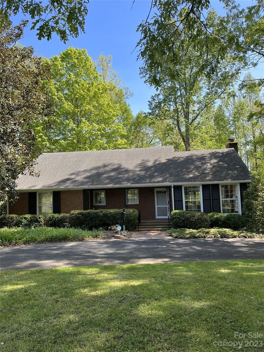 Charming home with exquisite hardwood flooring, decorative extra-large crown moldings, floor to ceiling windows, fine craftsmanship details of an older well-built home.  Beautiful family room with a fireplace that opens to the dreamy sunroom.  The kitchen has fantastic windows overlooking the gorgeous flat back yard and stream. This kitchen is the perfect central hub of the home offering an eat-at bar, secondary den or dining with a fireplace and a bay window, tons of storage and a drop zone hallway.   Primary bedroom and second room on the main level. Upper level offers two large bedrooms and a jack and jill bathroom.  Massive walk-in attic storage.  Newer HVAC, Hot Water Tank and backup generator.    Two car garage on the massive lower level also has a bonus room with a bathroom, needs some TLC but could provide a secondary living area. This home is in a well-established neighborhood just minutes to uptown Shelby.