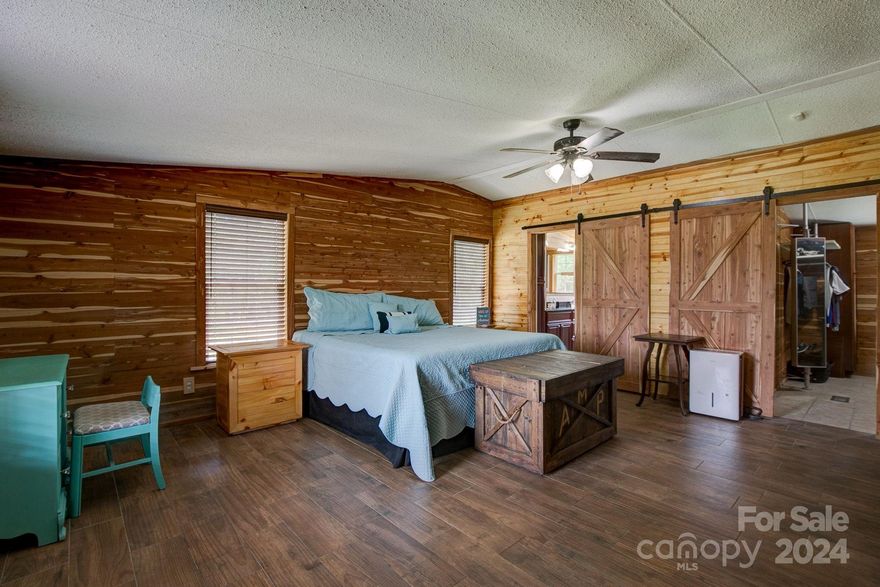 Welcome to 498 Hillcrest Road, nestled in the charming town of McBee, SC. This spacious four-bedroom, two-bathroom home offers a serene and peaceful lifestyle on 1.7 acres, away from the hustle and bustle. The current owners have poured their heart and soul into this home, evident in the multitude of custom touches throughout.
The master bedroom is a true highlight, featuring beautiful custom barn doors, knotty pine walls, a massive walk-in closet with an island, and a private master bathroom with a custom-tiled walk-in shower and a custom vanity with granite countertops. The kitchen is a chef's dream, boasting brand new custom cabinetry, granite countertops, a large island with a gas cooktop, and top-of-the-line appliances that convey with the home. Additionally, the property includes a 1,200 square foot metal-enclosed building, perfect for a workshop, storage, gym, or office, with an attached carport conveniently located next to the home. This property is a must-see! DETITLED