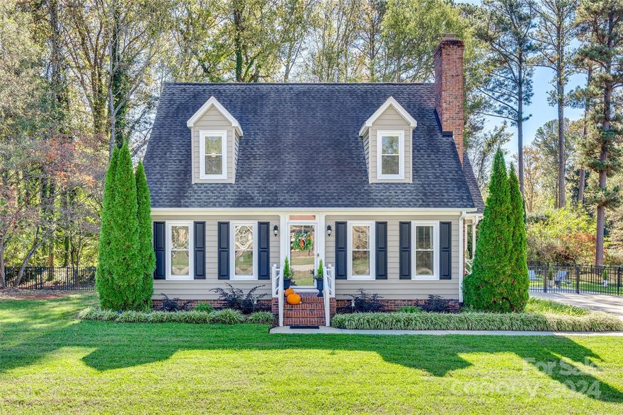 Charming Cape Cod home located in the established, quiet neighborhood of Greenfield Acres. The home has stunning hardwood floors throughout! A truly inviting property that offers a classic appeal with modern features and a kitchen sure to impress! Quarts counters, tile backsplash, stainless steel appliances, ample cabinet storage, all designed for style and function. Gas logs, special molding, tasteful fixtures & hardware make this home stand out from the rest. Just off the kitchen, you can relax in a cozy sunroom filled with natural light, while enjoying the private scenic view. The fenced  back yard has a wonderful patio for entertaining friends and family. Primary bed and bath are on the main level as well as another bedroom and half bath. Two additional bedrooms and a bath upstairs provide even more flexible use space. No HOA, but all the advantages of city limit services.