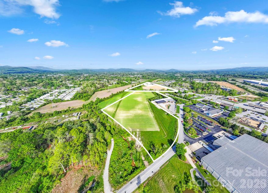 Exceptional large-scale development opportunity in one of Henderson County’s most strategic and rapidly expanding commercial corridors. This ±27.68 acre tract is ideally positioned at the Upward Road interchange along I-26, offering outstanding visibility, accessibility, and connectivity within the highly desirable South Asheville / Hendersonville growth corridor. With approximately 1,300 feet of frontage along Upward Road and additional frontage on Commercial Boulevard within the established Appleland Business Park, the property benefits from excellent access, strong traffic exposure, and multiple points of ingress and egress. Its location at a signalized interchange provides direct connectivity to I-26, allowing for efficient regional access to Asheville, Hendersonville, and Upstate South Carolina—making it highly attractive for a wide range of commercial and industrial users. The land is predominantly level and has been previously utilized for agriculture, creating a highly efficient and cost-effective development site with minimal grading requirements. This combination of scale and usability is increasingly rare in today’s market, particularly in a corridor experiencing strong population growth, expanding infrastructure, and increasing demand for commercial and industrial space. Zoned RC (Regional Commercial), the property offers exceptional flexibility, allowing for a broad range of uses including industrial flex development, light manufacturing, distribution, multi-family residential, retail centers, office campuses, hospitality, and mixed-use projects. This versatility enables developers and investors to adapt to market conditions and pursue multiple development strategies within a single site. A significant advantage of this property is the availability of key infrastructure, including public water and sewer, natural gas, and three-phase power, providing the critical utilities necessary to support modern commercial, industrial, and residential development. These utility capabilities substantially reduce development timelines and costs while enhancing the site’s appeal for both institutional investors and owner-users. Surrounded by a growing mix of commercial, industrial, and residential development, the property benefits from strong demographics, increasing traffic counts, and proximity to major employment centers and regional amenities, including Asheville Regional Airport. Its positioning within Appleland Business Park provides an established commercial environment with nearby complementary uses, while still offering the scale and flexibility needed for larger, more impactful development. Additionally, the combination of interstate access, multiple road frontages, and a highly visible location creates opportunities for phased development, multi-tenant projects, or a single large-scale user. Whether envisioned as a multi-building industrial flex park, a residential multi-family community, a mixed-use development, or a commercial retail center, this property offers the foundational elements necessary for a successful project: location, infrastructure, visibility, and flexibility. In a market where large, well-located tracts with full utility access and interstate proximity are increasingly scarce, this offering represents a rare opportunity to secure a premier development site capable of supporting a wide range of high-demand uses.