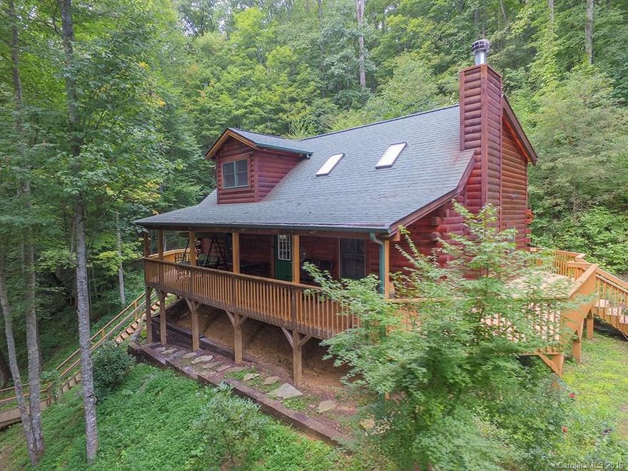 Quaint log home on over 2 acres & a mountain creek!  Home features lots of decking (some covered), open main level floor plan, loft area perfect for office, & large bedrooms.  Take the stairs down to the sitting area by the creek or enjoy the sites & sounds from the covered front deck. The wood burning fireplace will be wonderful on those cool mountain nights. Use as a full time residence, 2nd home, or vacation rental. Located close to Maggie Valley & Waynesville. Paved drive & lots of parking!