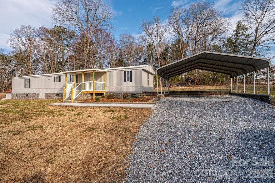Three-bedroom, 2 full bath manufactured home perfectly situated on nearly a half-acre lot.  Permanently attached to the property with beautiful, professionally installed building clocks. A brand new back covered deck and a covered front porch, this home welcomes friends and family to stay a bit!  New gravel leads you to the oversized carport where you can park your cars out of the weather.  New concrete sidewalk leads you right to the front porch and into the home!  All kitchen appliances stay as well as the washer/dryer and the stand-up freezer!  Head out the back door onto another nice, covered deck.  String some lights and it becomes a great outdoor living space in the spring and fall!  Also with this property, there are two workshops, both with electricity.  Makes a perfect place for storage or a wood working shop.  Perfect Flex space for you to do whatever you want!   Call today to take a look!
