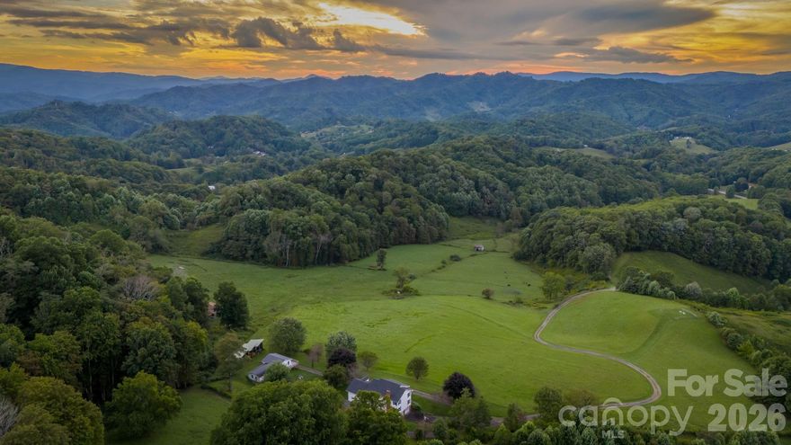 Apple Tree Farm - a rare offering of 243+ acres with a farmhouse, unfinished garage/building, storage building, two barns, and trails - with wooded acreage, sprawling pastures, and long-range, layered Blue Ridge Mountain views at high elevations. With the potential for many different uses, this is the perfect spot for a homestead, family estate/legacy property, horse property, working farm with farming opportunities, or investment opportunity with potential for development - no zoning and no restrictions! Offering easy access year-round from state-maintained roads, this property is just 15 minutes from Appalachian State University and amenities in Boone but offers ample privacy. The large farmhouse front porch is the perfect place for overlooking the green pastures, small pond, and mountains beyond - enjoy mother nature at her finest with acres and acres made for exploring and enjoying the cool Blue Ridge Mountain air! The 3 BR, 2.5 BA home, awaiting the right buyer to put their own personal touches, offers a living room, den, kitchen, and dining room on the first level - upstairs, find a large primary suite, two additional bedrooms, a full bath, and multiple bonus rooms. Additional features: central vacuum, recently replaced windows throughout, wormy chestnut kitchen cabinets, four garage bays, full basement with bathroom, high-speed internet. The farmhouse would also make a great guest home, with the opportunity to build on the acreage! The unfinished garage/building was originally intended as a garage with an apartment above and offers four additional garage bays. An open-air storage building is great for equipment or vehicle storage, and a large usable barn offers even more potential. Apple trees & wildflowers surround the farmhouse and a trail system runs through parts of the wooded acreage to pasture areas. The serenity of Apple Tree Farm lasts year-round with pastoral and sunset views overlooking the majestic Blue Ridge Mountains! As of January 2026, sellers are in the process of selling off a 3-acre portion of tract 1993-20-6423-000 - see visual; survey forthcoming.