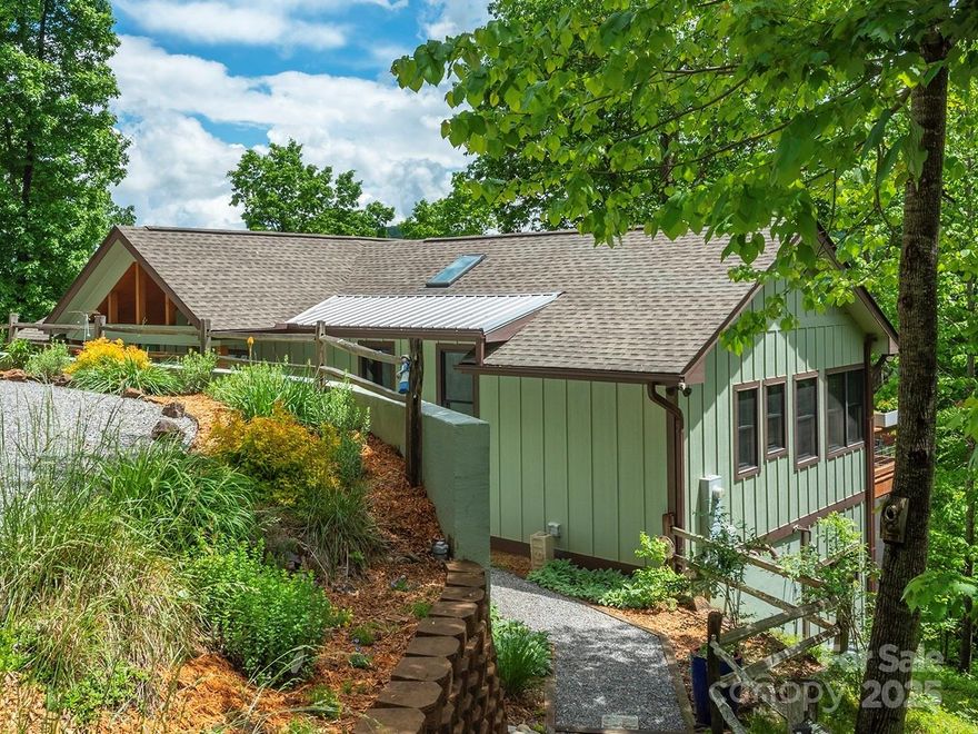 Elegant Contemporary design meets Arts and Crafts with year round mountain views nestled in the quaint Quail Ridge neighborhood just minutes from downtown Waynesville. Streams of natural light, an inviting spacious floor plan, beautiful open kitchen, and large luminous windows leading to cozy screened decks lend themselves perfectly for entertaining and taking in the serenity. Main level primary bedroom boasts mountain views from oversized windows with walk-in closet. Custom cabinets and built-ins welcome you to the airy ensuite full bath. Thoughtfully finished lower level offers a generous entertaining area with kitchenette, reading nook, beautifully tiled full bathroom with soaking tub, and access to covered decks with hot tub. Guest bedroom also offers screened deck access with plenty of options for relaxing. Two car garage with interior and deck access lead to ample driveway parking. This home has the perfect balance of mountain living with city amenities just a short drive away!