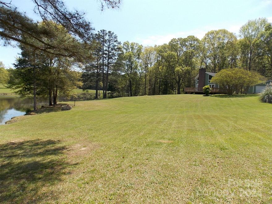 Remarkable views of rolling acreage and tranquil pond.  Stunning wall of glass brings in bountiful light and a picture of beauty whether upstairs or down.  New plank flooring, carpet, and paint will give you a fresh start.  You will find a newer, 795 sq ft, wired and plumbed, garage/workshop, oversized with 2 bays and man door, wired RV hook-up, rear lean-to for the tractor, concrete parking, and newly added layer of driveway gravel.  Rough-sawn Cedar siding recently coated. This unique 70's contemporary-style home offers flexible living spaces, generous storage, and inviting outdoor privacy. Step through the French Doors and lounge on an oversized deck to watch the evening glow flicker across the water.  A home lovingly cared for, nestled on gated and fenced acreage. Come see for yourself!