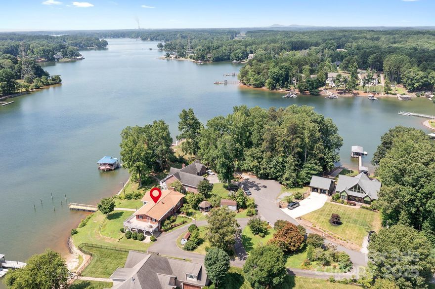 Don't miss the opportunity to make this Lake Norman property your own! This unique waterfront home is situated on a picturesque peninsula at the end of a tranquil dead-end street. This 4-bedroom, 3 1/2-bath home features stacked sunrooms on each floor facing the lake with walls of windows. Enjoy serene mornings and breathtaking sunsets from the expansive wraparound deck, perfect for entertaining or relaxing in total tranquility. Situated on a .62-acre lot with 117' of waterfront, this home offers endless opportunities for water activities. The unique floor plan presents a fantastic opportunity for multi-generational living, potential long or short-term rentals with lots of parking for cars, boats, and RV. You have the freedom to personalize & transform this gem into your dream home. No HOA. Home Sold as Is. No Repairs to be made