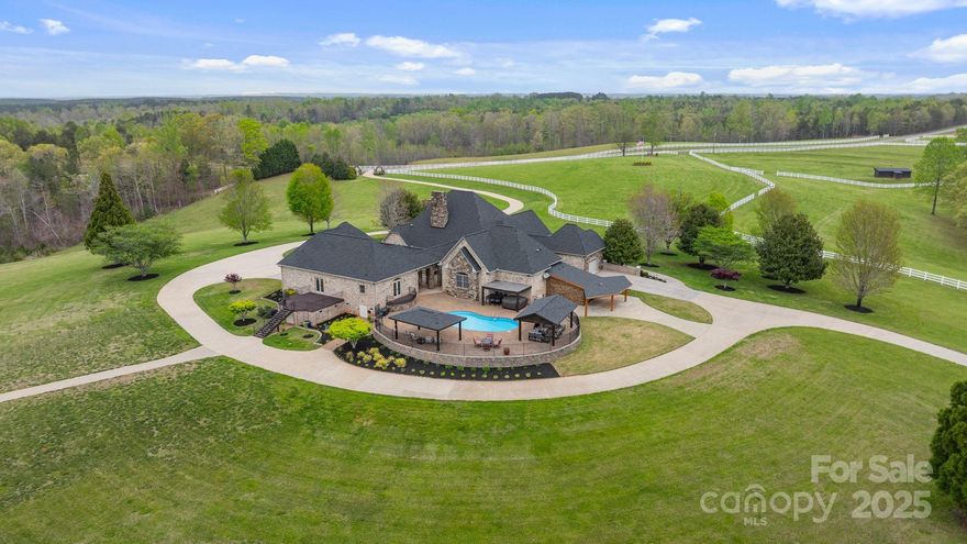 Nestled on 72+ acres of rolling pasture at the base of the Blue Ridge Mountains, this exceptional estate is a rare fusion of luxury, versatility, and breathtaking views. The primary residence offers 3,361 sqft of elegant living with three en-suite bedrooms, soaring 20 ft. ceilings, a gourmet kitchen, and a seamless connection to a private guest house via a charming breezeway. Designed for entertaining and lifestyle flexibility, the estate features a stunning pool, hot tub, 2 covered pavilions, and expansive terraces. Mulltiple guest cabins, and 16 bay vintage-style garage and motorcoach-ready storage building—convertible to equestrian use. A separate event center with ballroom, bar, prep kitchen and outdoor pavilion adds limitless possibilities. Above event center is another guest apartment/bridal suite. Whether you're a horse enthusiast, event host/entertainer, or car collector, this gated estate redefines private luxury living—just minutes from Tryon International Equestrian Center.