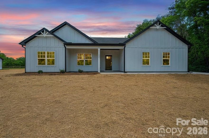 Modern farmhouse design meets relaxed living in this beautifully crafted new construction home situated on a level .77-acre lot. Offering over 2,400 square feet of single level living space, this 4-bedroom, 2.5-bath residence combines style and function with a thoughtful layout and no carpet throughout for a clean, modern finish. Hardie board siding accented with black trim creates striking curb appeal with a timeless farmhouse influence. Inside, the open floor plan is designed for both everyday living and entertaining. The kitchen stands out with an expansive island, abundant cabinetry, soft-close drawers, and stainless steel appliances, seamlessly connecting to the dining and living areas for a spacious, open feel. The split-bedroom design enhances privacy, with an oversized primary suite featuring an oversized bath complete with dual vanities, tiled flooring, tiled shower, and a large walk-in closet. Enjoy year-round outdoor living on the covered rear sitting area, perfect for relaxing or hosting guests, along with a welcoming front porch that overlooks the expansive yard. The oversized side-entry garage, professionally finished with epoxy flooring, provides excellent space for storage, a workshop, or hobbies. Ideally located with quick access to Highway 321, this end home offers extra privacy, storage galore, and a comfortable balance of convenience and space for everyone.
