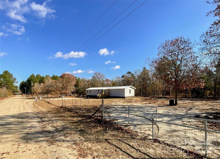 Almost 2 acres plus a remodeled 3 BR/2 BA single wide manufactured home. With lien payoff at closing, DMV will release title so it can be retired and home/deed can be attached to the land. New in 2024: metal roof; HVAC unit; windows; interior and exterior doors; drywall and paint; vinyl plank floor covering; kitchen cabinets, countertops, sink, refrigerator and range; front and back covered porches; brick to replace vinyl skirting; bathroom vanities; and light fixtures. No permits were obtained. Owner will have the septic pumped and inspected. Great property to use for your 1st home, your stepping-stone, your retirement home or your forever place. Plenty of outdoor space for people, pets, plants, and play. Check it out.