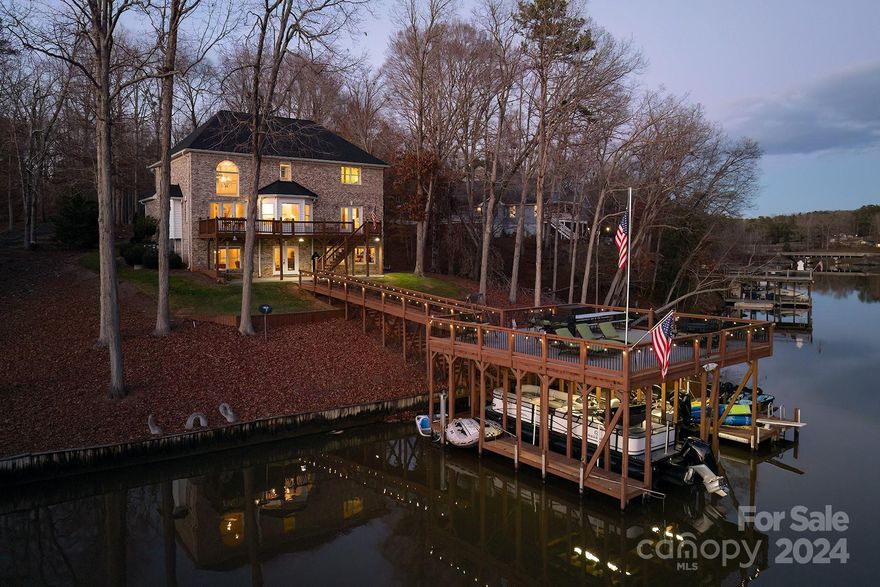 Fully Furnished! One of a Kind Boathouse w/ Deep water plus a private bridge from the yard to the huge sundeck on top of the boathouse! The home sits very close to the water & has several areas for entertaining & al fresco dining! Beautiful entrance w/ open stairway, hardwood flooring, formal dining & living areas, 2 story great room overlooking the lake with fireplace. White kitchen w/ granite countertops & breakfast area overlooking the water. Large owner’s suite w/ water view, large bath area and walk in closet. Fantastic lower level with a second full kitchen with beautiful cabinets and black granite countertops that opens into a large family room with fireplace, tile flooring and lots of glass overlooking the lake and concrete patio.4 total bedrooms with 2 wonderful extra bonus rooms to be used as you like. Large 2 car garage plus another 1 car garage in basement. Beautiful spaces, and wonderful landscaping! Only 6 miles from Albemarle w/ restaurants & shopping! Must see this one!
