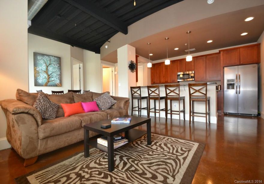 Hip Two Bedroom Two Bath Condo In The Heart of It All! This One Has The Appeal Of A Loft With Exposed 12 Foot Ceilings, Concrete Floors And The Privacy Of 8 Foot Bedroom Doors!   Expansive Granite Counter Tops, Stainless Steel Appliances, Open Floor Plan, 8 Foot Custom Doors!!  Walk to NoDa Brewery, Amelie's!  Check Out The Skyline Views of Uptown and Charlotte's Sunsets From The Roof Top Patio!  So Close to Uptown and The Heart of The Arts District! Two Blocks from Confirmed Light Rail Station!