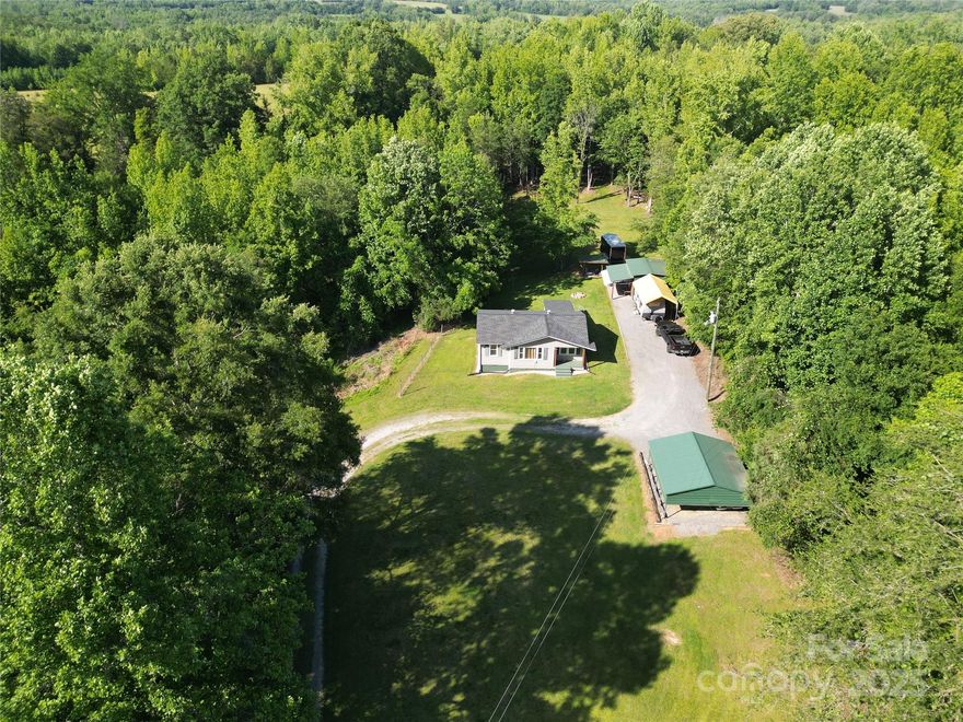 Escape to the peace and privacy of this charming 2-bedroom, 1-bath bungalow situated on 9.97 serene acres—just 15 miles from I-85 for easy commuting. Surrounded by hundreds of wooded acres, including across the street, this property offers unmatched privacy and a true sense of seclusion. Inside, you’ll find updates including brand-new LVP flooring and fresh paint throughout. A new roof and tankless water heater were installed in 2023, adding value and peace of mind. The living room features a large picture window that fills the space with natural light. A separate laundry room adds convenience, while new baseboard heating and window AC units provide year-round comfort. Step outside and enjoy your very own retreat with a tree house and fire pit—ideal for relaxing evenings or entertaining guests. A 22x24 carport and a 12x16 powered workshop offer great storage and space for hobbies or projects. A unique opportunity to own a private slice of Gaffney!