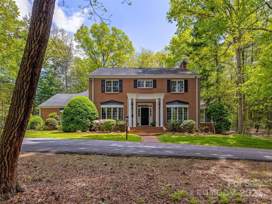 A gracious traditional home within walking/biking distance to Carolina Day School and the membership Country Club. Sited on two nearly level wooded acres this spacious home has amenities galore from the formal rooms to the sunroom, family room and main floor primary with excellent bath and closet space. The sunny kitchen has a breakfast and bar area. A complete apartment over the three car garage has a full kitchen/great room as well as a bedroom and bath. It is privately located but accessible from the main house. A second primary is one of 5 bedrooms 3 baths on the upper level. The basement level has theater and rec areas and a bath.