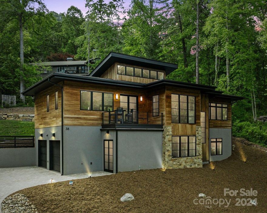 Enjoy the pinnacle of contemporary mountain living w/ this stunning, ultra-modern masterpiece located in prime North Asheville, directly across from 16th tee of the Asheville Country Club. Custom-built to embody clean simplicity & embrace the rolling mountain landscape, this 3 BR/2.5 BA sanctuary features an extensive open-concept floor plan w/high ceilings & ample natural light. Top-of-the-line amenities throughout, combining functionality & sleek aesthetics. $30K credit at closing for elevator installation. 
 
Notable highlights: true chef’s kitchen with honed marble countertops & luxury appliances; floating metal staircase with oak treads; floor-to-ceiling stone fireplace in great room; artisan-crafted powder room vanity & mirror w/stone sink; folding glass panel doors for seamless indoor/outdoor transition to sprawling screen porch & outdoor pavilion FP & patio, ideal for entertaining. 
 
A scenic 10-min drive from the heart of downtown Asheville, a bustling cultural mecca.