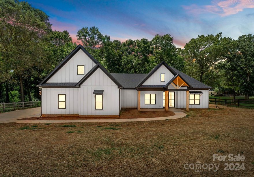 ***MOTIVATED SELLER***Step into the epitome of contemporary farmhouse charm with this new construction home on a one-acre lot. Located in rural Waxhaw, this meticulously crafted home blends rustic elegance with modern conveniences. The open-concept vaulted great room features an electric fireplace and flows seamlessly into the gourmet kitchen, which boasts a large center island, quartz countertops, ss appliances, custom cabinetry and a butler’s pantry – a chef's dream! Entertain effortlessly w/ adjacent dining area, perfect for hosting gatherings. Back door opens onto a large covered 20X20 screened patio and sprawling fenced backyard, with outdoor living and enjoying the serene Carolina skies. The primary suite offers a luxurious ensuite bathroom complete with a soaking tub, dual vanities and walk in closets. Upstairs bedroom/bonus room ideal for a media room, playroom, or home gym. Spacious laundry room, 3 car garage. no HOA. Enjoy downtown Waxhaw while being close to SC border