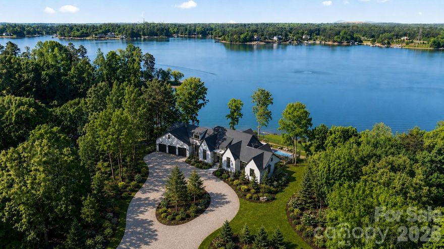 Set on a rare 1.42-acre waterfront lot with over 500’ of Lake Norman shoreline with big open water main channel views. This new custom estate built by CTR Homes and designed by Sara Lynn Brennan Interior delivers a seamless blend of architectural elegance, cutting-edge smart living, and resort-style comfort, all designed for those who expect more from every detail. From the moment you arrive, the home’s modern exterior, expansive driveway, and 3-car garage with epoxy floors establish presence. Inside, soaring ceilings, hardwood floors, and curated finishes create a refined yet inviting atmosphere that immediately feels like home. The heart of the home is a stunning open-concept living space framed by bronze Andersen windows that flood the interior with natural light and capture uninterrupted Lake Norman waterfront views. The designer kitchen is both a showpiece and a chef’s dream, featuring marble countertops, a 48-inch Thermador gas range, top-tier appliances, and a fully equipped scullery with a built-in app-controlled coffee system, second dishwasher, prep sink, microwave, fridge drawer and freezer drawer. The main-level primary suite is a private retreat designed for comfort and indulgence, complete with a boutique-style custom closet featuring its own island, chandelier, and in-suite washer and dryer. The spa-inspired primary bath elevates daily living with heated floors and programmable shower settings, delivering a personalized luxury experience every day. The lower level fully finished walk-out basement transforms into an entertainer’s dream and a private guest haven. With three additional bedrooms, 2 full baths, a media room, fitness room, rec room, custom bar, and dedicated lake bathroom, every inch of space is intentional and elevated. A climate-controlled wet storage area ensures effortless lake living year-round. Step outside and the lifestyle truly begins. Enjoy a heated pool and spa, outdoor gas grill, and fully fenced backyard, all designed for both intimate evenings and large-scale entertaining. Your private waterfront experience is complete with a brand-new dock and pier with boat lift, offering direct access to the best of Lake Norman boating. This home is fully equipped with indoor-outdoor surround sound, touchscreen lighting controls, security cameras, and two tankless water heaters, blending luxury with smart efficiency. Located near Lake Norman State Park, marinas, golf courses, and top dining destinations, this property offers both privacy and convenience, with easy access to Mooresville and Charlotte. No compromises. Just elevated living. Tinker Rd will be paved upon completion of build.