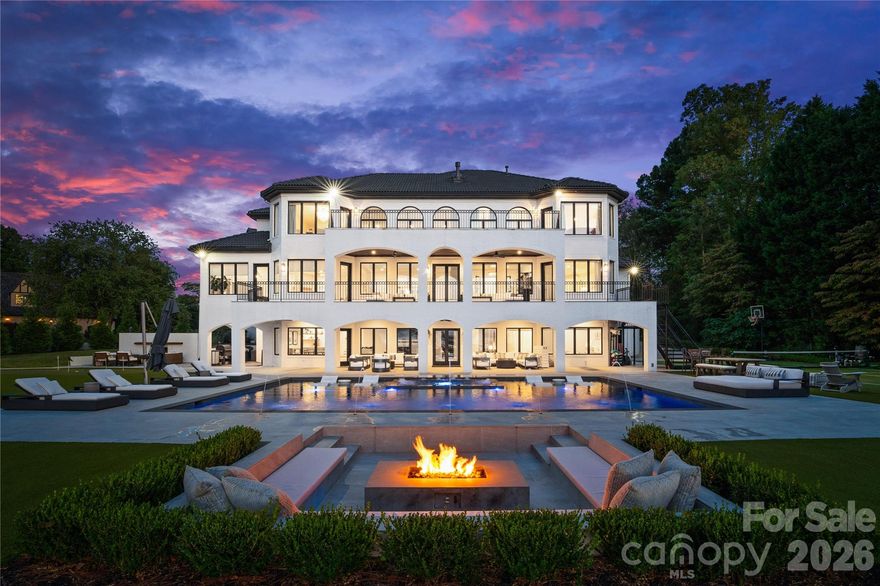 A true waterfront masterpiece, this striking modern Mediterranean estate seamlessly blends refined luxury with relaxed coastal elegance. Privately set behind dual gates on a sprawling 1.12-acre homesite, the property captures breathtaking long-range Lake Norman views and offers a sense of arrival that is both impressive and serene. Inside, light-filled interiors showcase an open-concept design defined by clean architectural lines, soaring spaces, and an effortless connection to the outdoors. Walls of glass invite natural light throughout, creating a bright, airy atmosphere ideal for both everyday living and elevated entertaining. Expansive outdoor terraces set the stage for unforgettable evenings, perfect for sunset cocktails or hosting guests. At the heart of the home, the gourmet kitchen is a chef’s dream, featuring Wolf and Sub-Zero appliances, a dedicated scullery, marble countertops, and custom white oak cabinetry designed for both beauty and function. The lower-level transforms entertaining into an experience of its own, complete with a full bar, fitness room, sauna, and a private ensuite bedroom, ideal for guests or extended stays. Step outside to your own private resort-style oasis. An expansive heated, saltwater pool and spa anchor the outdoor living space, complemented by a pickleball court, putting green, low-maintenance turfed yard, outdoor fireplace, and grilling area—every detail thoughtfully designed for relaxation and recreation. For boating enthusiasts, the covered private dock with lift offers effortless access to the water, whether you’re setting out for a day on the lake or enjoying the peaceful surroundings from the shoreline. A 4-car garage provides ample space for vehicles, toys, and storage, completing this exceptional estate.