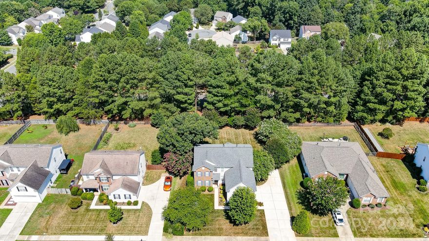 Welcome home to this beautiful, bright, spacious home on a nice, flat, treed lot. LVP floors (2023) on main level. Updated kitchen (2023) to include white cabinets w/pullouts, stone backsplash, island and lighting. Built-in planning desk in kitchen area. Kitchen & DR lights have dimmer switches & ceiling fans thru-out.  Large primary bedrm w/large walk-in closet. Primary bath has double bowl vanity sinks, garden tub & separate shower. Nice size secondary bedrooms. Bedroom 5/bonus has great space w/walk-in closet. New roof replaced this year, 2024. Lovely screeded in porch off the kitchen & added ceramic tile floors in 2023. Huge, beautiful fenced back yard w/lots of mature trees/shrubs. Nice stone/brick paved area in the rear yard to put a fire pit on and relax. Oversized side load garage w/tons of storage space inside. Xtra long driveway provides lots of space. Minutes to all interstates, Research Park, grocery, shopping & dining.