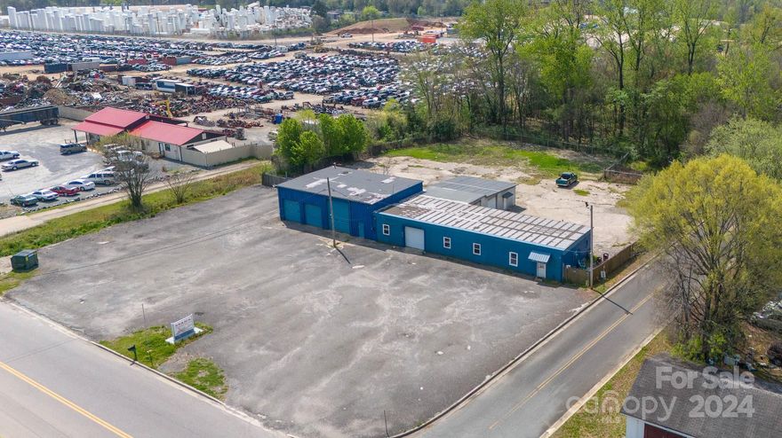 Calling all automotive enthusiasts & business owners! Exceptional opportunity for an auto shop venture. Generous 5,389 sq ft of versatile space equipped with 8 spacious bays, including 3 lifts. Mechanics will find ample room to service vehicles of all sizes. The tire machine, newer air compressor & toolboxes ensure that operations run smoothly & effectively. The addition of vending machines provides clients & staff access to refreshments/snacks without having to leave the premises. There is also a designated office area, offering a professional space for administrative tasks & client consultations as well as a 16-camera security system that will stay. 2 half baths are conveniently located in the building. Parking is never an issue on this expansive 2.1-acre lot, there is plenty of room for customer vehicles & employee parking. Substantial fenced area, ideal for storing vehicles or equipment overnight. Property line extends beyond the fencing, offering potential for further development.