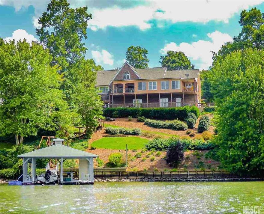 Stunning panoramic views of Lake Hickory's main channel! This meticulously maintained three level home in Moore's Ferry has been beautifully updated inside and out, and offers over 4,700 HSF! The main level offers an inviting front entry with arched front door and iron railing staircase. The open concept living room-dining room features a corner gas fireplace and adjoining kitchen with stainless appliances, island, and breakfast room overlooking the lake. The huge master suite has a sitting area overlooking the water, private deck, & bath with double vanity and water closet. You'll also find a 2nd master suite on the main level with corner tub and tiled shower. Upstairs, two bedroom and a home office share a hall bath. The full lower level offers an enormous rec room, large 5th bedroom, 4th full bath, laundry, & double garage with workshop space. Two covered decks, groomed lawn, and a new walkway to the the lake with waterfront sun deck & covered dock. Community pool & clubhouse.