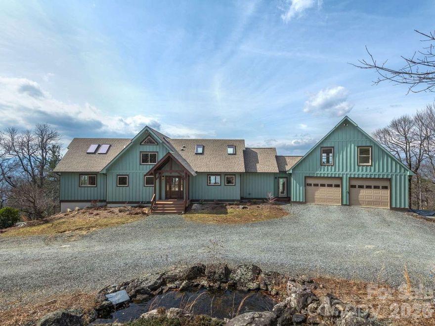 Escape to your own private mountain retreat in this stunning custom-built timber frame home overlooking the Little River Valley. Set on just over an acre, this thoughtfully designed 3-bedroom, 3-bath residence offers 3,680 sq ft of living space with breathtaking long-range views of Pisgah National Forest, Looking Glass, and sections of the Blue Ridge Parkway visible from most rooms. Strategically updated in 2025, the home blends rustic mountain charm with modern efficiency and durability. Comfort is unmatched with radiant in-floor heat throughout all 6,300 sq ft under roof, including both the upper and lower attached garages. Step outside to newly built decks designed for entertaining or quiet relaxation while taking in sweeping mountain views. The property also features a custom waterfall feature at the front entrance, creating a dramatic and welcoming arrival. Built with resiliency, efficiency and longevity in mind, the home includes 10-foot-tall Superior Walls on the lower level, and an impressive steel reinforced lower garage with access to the whole-house generator bunker. Nature lovers will appreciate the abundant blackberries and wild blueberries growing below the home, along with space for gardening near the 480 sq ft detached carport with 240 sq ft of enclosed storage for all of your gardening tools. A new gravel entrance from Jeter Mountain Road provides easy access to this private mountaintop escape. Best of all—NO HOA and additional acreage may be available for purchase, offering even more opportunity to expand your mountain sanctuary. This is a rare opportunity to own a private, resilient, and thoughtfully engineered mountain home with spectacular views. Property is gated with no turn around, no drive bys.