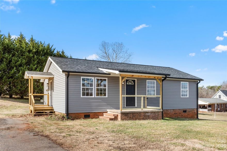 Stunning mountain views from this completely remodeled home. New roof & gutters. New siding. New luxury vinyl plank flooring and paint throughout.  The gorgeous NEW kitchen comes with brand new appliances - fridge, stove and microwave! Dining area with sliding glass doors out to the NEW back deck. The NEW bathroom is luxurious! Electric and plumbing upgrades. New lighting throughout. Enjoy the mountain views from your front porch, from the primary bedroom and from the backyard. 
The front and back yards are huge, plenty of room for kids and pets to play. Large concrete patio with built-in stone fire pit. There's a side porch with entry into the kitchen.  Big laundry closet with storage. City water, sewer and garbage pick-up keeps costs low.
This beautifully updated home offers in the country privacy but convenient and close to everything you need. 5 minutes to downtown Forest City, convenient to Hwy 74. You'll love the farm store down the street for fresh eggs, baked goods & more!