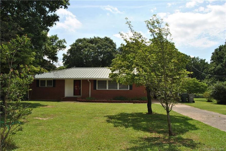 Double flat lot with beautiful mature trees in a quiet, peaceful, convenient neighborhood. Two storage buildings and a 10X12 wired greenhouse. Energy Efficient with new windows, newer HVAC, new metal roof. Remodeled kitchen with ceramic tile, stainless appliances. Large master bedroom with double closets.  Updated baths. Hardwoods under carpet in Living Room (per seller). Huge full basement. Enclosed porch with outdoor carpeting. Parcel #136215 included to make .87 acres per seller.