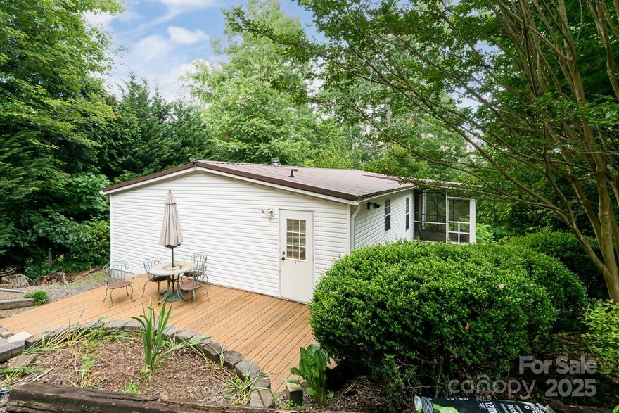 Privacy and views! Tucked into the trees in a small, quiet community, 129 Oak Trails is a pristine 2-bedroom, 1,200 square foot doublewide on a permanent foundation.  Just spruced up and updated, the house is truly move-in ready, with updated bathrooms, a tankless water heater and newer 15 SEER variable speed heat pump for your comfort.  The large .66-acre wooded lot has long-range winter mountain views, and with a bit of trimming the views could be year-round.  There's a screened in porch and large patio for year-round outdoor living, and a cozy fireplace in the living room for those extra-chilly days.  The family room gives you plenty of space for dining and entertainment, and there's even a small office/utility room.  The large metal carport is included as well.  Use as your primary residence or rent the house for additional income.