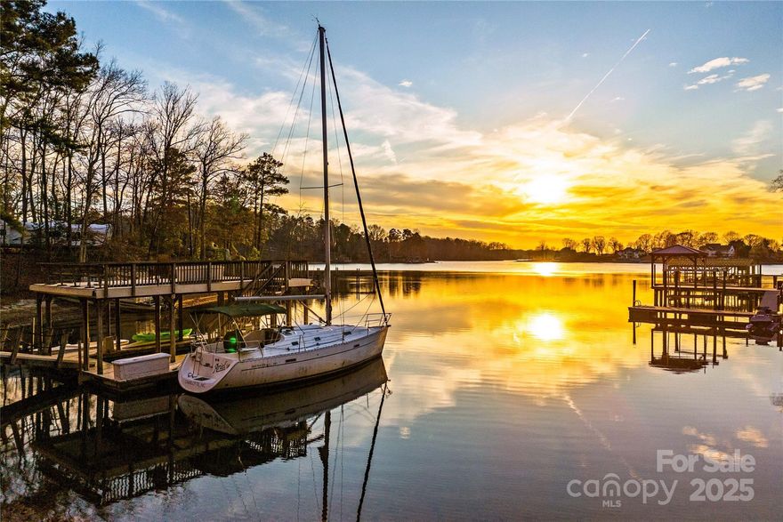 Discover this truly gorgeous and rare 2.72-acre waterfront lot on the highly sought-after shores of Lake Norman. Boasting an expansive 233 feet of prime waterfrontage and 333 feet of road frontage, this property is a boater's and nature lover's paradise, featuring a beautiful natural sandy beach for swimming, paddle boarding & evening bonfire stories. Enjoy breathtaking, long-range sunset views from your double decker dock, perfect for relaxing and entertaining. The lot is ready for your dream home with a protective stone retaining wall already in place at the water's edge. A significant advantage of this property is its potential for two separate residences. A soil scientist has noted two distinct areas that can accommodate two septic fields, offering flexibility for a large estate home or a family compound (per county guidelines). The lot is private and secure, featuring front fencing with dual gate entries for access. Natural beauty abounds with mature, majestic hardwood trees and impressive natural stone boulder outcroppings that add character and unique landscaping opportunities. The mid-lake location lends itself to easy boating commutes to both the northern and the southern ends of Lake Norman, as well as close proximity to restaurants and bars for a quick bite or cocktail hour. Don't miss this chance to build your custom estate on one of Lake Norman's finest parcels!