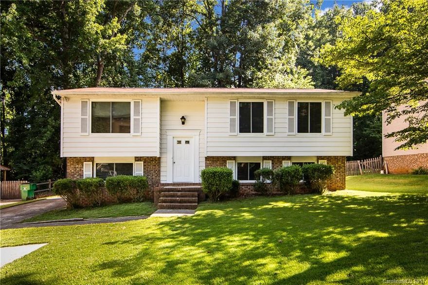 Spacious, freshly painted split level home. Features open living room & dining area w/glass sliding door that leads to back deck overlooking wooded backyard and additional lower deck for entertaining. Kitchen includes stove/oven, dishwasher & disposal. MBR has stand up shower. Lower level has one bedroom, one bathroom & separate living room/bonus room. Unfinished utility room downstairs includes storage & laundry. Refrigerator & washer/dryer included. New windows installed 2013. CLOSE to UNCC