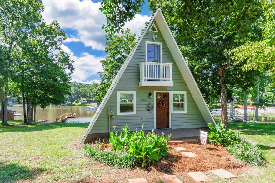 Experience the charm and serenity of lakefront living with this delightful A-frame home on High Rock Lake! Boasting exceptional curb appeal, this property features a welcoming walk-out balcony on the upper level. Inside, the home has been meticulously updated with all-new windows and a stunning bathroom featuring an oversized shower. Enjoy the spacious, brand-new deck at the back, perfect for taking in the breathtaking lake views. The new 80-foot dock and private boat launch make lake access effortless, while the newly installed gutters and refurbished carport add to the home's appeal. With a shed on the property, no HOA, and a recently repaved main road, this adorable home is ready for you to fall in love with. Don’t miss your chance to own this perfect lakeside retreat!