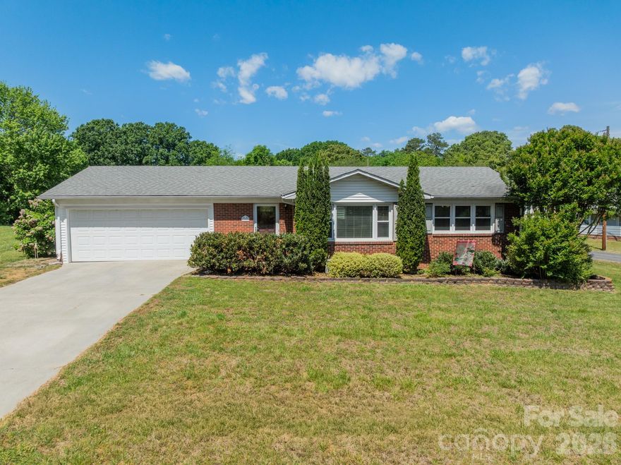 Welcome to 307 Winona Avenue, a charming brick ranch set on a spacious corner lot with mature landscaping and decades of careful ownership. Thoughtfully designed, the layout offers a comfortable blend of open living spaces and private retreats.  Step inside to a welcoming, light-filled family room that flows easily into the kitchen, complete with ample cabinet storage, a dedicated dining area and convenient access to the laundry space. All three bedrooms are generously sized and filled with natural light, offering flexibility for guests or a home office.
Outside, enjoy a fully fenced backyard—perfect for pets, play, or entertaining—along with a two-car attached garage for added convenience. Ideally located just minutes from Village Park, Bakers Creek Park and downtown Kannapolis—home to the Atrium Health Ballpark, local dining, shopping, and year-round events—this home combines everyday comfort with easy access to local amenities.  Move-in ready and full of potential—schedule your showing today!