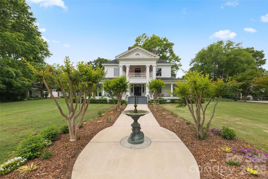 This Neo-Classical historic gem is on The National Register of Historic Places, and zoned to be a Bed in Breakfast, if you desire!  Enjoy sitting on the wraparound porch with a
view of the exquisite landscaping and park across the street. This home has been meticulously maintained while keeping its
historic integrity intact. New Roof on the upper part of the home. Updated kitchen and butler's pantry with granite countertops, a large island, and a large porfessional gas range.
Plenty of space for entertaining, with two formal rooms and a large dining room. Upstairs has four bedrooms, two of which
are primary suites. Enjoy the conversation in the hall upstairs, leading to the upper balcony. At the end of the hall is a door
leading to the staircase to the attic, which has ample storage. Outside you will find a large patio leading to the inground
pool next to a large grass area. This large lot has so much privacy and a decent size vegetable garden.