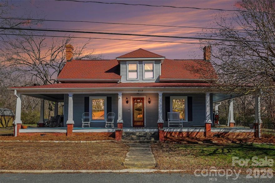 This beautifully preserved 1901 home blends timeless historic charm with thoughtful updates, set on a spacious 1.43-acre cleared and level lot with mature trees. With 2,609 square feet of living space across two stories, the home offers character, warmth, and room to grow.

A welcoming front porch sets the tone, inviting you to slow down and enjoy quiet mornings or evening conversations. Inside, you’ll find tall ceilings, rich wood flooring, and generously sized rooms filled with natural light. The family room features a fireplace framed by classic detailing, creating a cozy focal point while maintaining the home’s historic appeal.

The kitchen combines charm and functionality with white cabinetry, a large island, and ample prep space. It comes equipped with an electric range, microwave, and refrigerator with ice maker. Wood, tile, and carpet flooring throughout add warmth and texture, while thoughtful features such as an attic walk-in and walk-in closets provide practical storage.

The primary suite is conveniently located on the main level, offering comfort and accessibility, along with a full bath. Upstairs, two additional bedrooms and a full bath provide flexible space for guests, hobbies, or home office needs. A dedicated main-level laundry room adds everyday convenience 

Outdoors, the expansive lot offers endless possibilities for gardening, recreation, or simply enjoying wide-open space. The detached garage provides nearly 1,000 square feet and the additional outbuilding adds incredible versatility for a workshop, studio, or storage.

With no HOA this property delivers the rare combination of historic character, modern convenience, and room to spread out. It’s a special opportunity to own a piece of history with the space and flexibility today’s lifestyle demands.