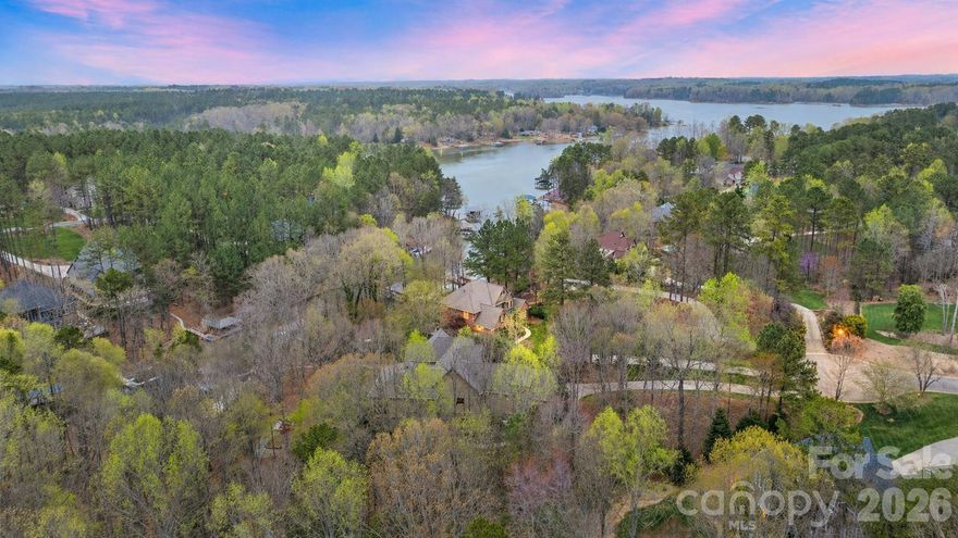 There’s lakefront… and then there’s Lake Norman done right.  With 167 feet of prime deep-water shoreline and over 6,100 square feet of well-executed living space, this home isn’t just sitting on the water — it’s built around the lifestyle that makes Lake Norman so special. From the moment you pull in, the curb appeal sets the tone. Manicured landscaping, a softly lit curved walkway, and a timeless brick-and-stone exterior create that immediate “this is it” feeling. Step inside and the two-story foyer opens up to expansive windows where the lake becomes the backdrop to everyday life.  The kitchen is exactly what you want in a home at this level — oversized island, high-end appliances, granite surfaces, abundant cabinetry, and a walk-in pantry. It flows naturally into the breakfast area and great room, anchored by a see-through fireplace that keeps the space open while adding warmth and character. The main level was designed for both entertaining and comfortable daily living — high ceilings, hardwood floors, custom millwork — quality you can feel. The primary suite is positioned to take full advantage of the water views. Wake up to the lake. End the day with sunset reflecting off the water. The bath delivers a true retreat with a soaking tub, custom glass shower, dual vanities, and a generous wardrobe space. Upstairs offers three oversized bedrooms and a media room that gives everyone their own space without ever feeling disconnected. Now let’s talk about what really separates this home. The lake level is over 1,900 square feet and has its own private entrance — which means opportunity. Full in-law suite. Private guest quarters. Multi-generational living. Long-term visitors who feel like they have their own home. It already includes a full gym, expansive family room with fireplace, bar and entertainment area — and it opens seamlessly to the patio and fire pit overlooking the water. Outside is where Lake Norman living truly comes to life. Follow the lit path down past the fire pit and fenced back yard to your private deep-water covered dock. This is weekends on the boat. Early morning fishing with coffee in hand. A quiet cove perfect for paddle boarding and kayaking with family and kids jumping off the dock. Sunset cruises that turn into dinner on the water. 167 feet of shoreline gives you privacy, room to spread out, and the kind of presence you simply can’t replicate. A home generator offers peace of mind. The 14-foot garage ceilings allow for a lift or serious storage for the car enthusiast. Located in highly sought after Northview Harbour, you also enjoy resort-style amenities — clubhouse, Olympic-sized pool, pickleball courts, walking trails — all while being minutes to shopping, dining, and top-rated schools.  This waterfront estate is ready for you to start making memories!

It’s Lake Norman living at its finest — where the lake isn’t a view… it’s your everyday experience.