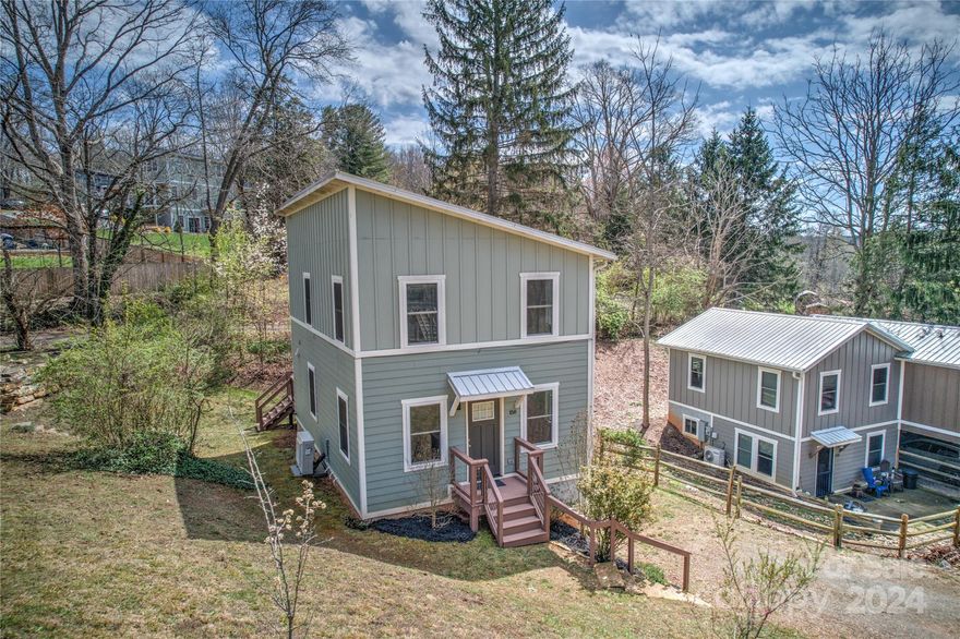 Welcome to this 6-year old North Asheville gem with an unbeatable blend of modern convenience and natural beauty. This 3bd/2.5b sanctuary is minutes from downtown, and a short stroll from upcoming Woodfin Waterfront Park. The flexible floor plan features exposed beams and an airy, organic feel in the communal area. Modern kitchen appliances with center island, powder room, and closets complete this level. Outdoor living is inviting, with a rear porch overlooking the backyard. Upstairs, find two sunny bedrooms with architectural vantage lofts, alongside the primary bedroom/full bath.  An additional full bath & laundry are on this floor. There are two parking areas, and room for a garden outside. This home features stunning bamboo floors, cabinets and ceramic tiling. Durable metal roof, insulated windows, zoned heating provide an energy efficient, yet luxurious lifestyle. Don’t miss the chance to make this cottage your new home!