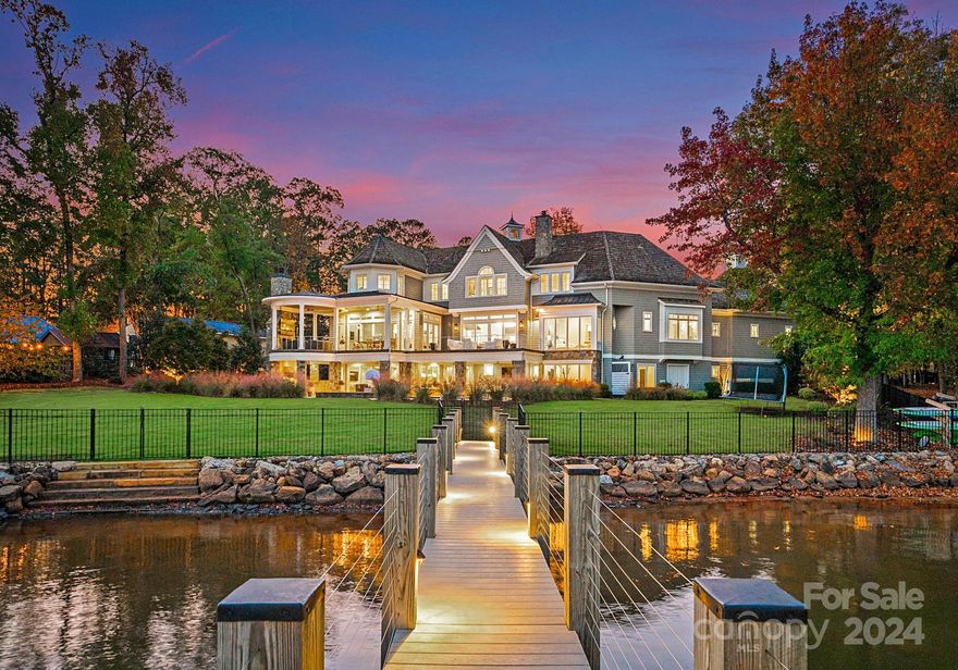 Presenting a breathtaking Nantucket-style estate w 200 feet of Lake Norman shoreline, designed by Ted Thompson for luxurious lakeside living and seamless indoor-outdoor flow. This 8,300 sq ft masterpiece offers 6 bedrooms, 7.5 baths, & endless spaces for entertaining or intimate family gatherings. Exterior features include gas lanterns, cedar shake roof & siding, stone accents, a circular driveway, and two double garages. The backyard invites entertaining w a custom designed pool, built-in kitchen, outdoor shower, & cozy firepit, all set against the stunning backdrop of LKN. Inside, wide plank floors, lead to a great room with a custom limestone fireplace & panoramic lake views. The chef’s kitchen boasts a Wolf double range, Thermador fridge, Sub-Zero wine fridge, Calcutta marble, and a scullery with ample storage. Complete w an exercise room, entertainment-ready basement, & pool bath, this estate defines lakeside luxury, offering an unparalleled lifestyle on the shores of Lake Norman.