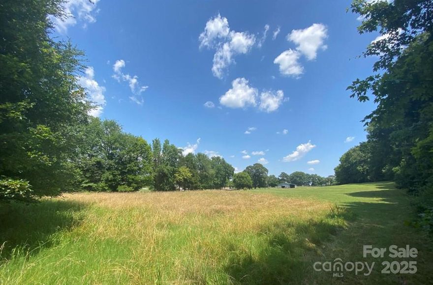 Approx. +/-4.9 acres combining 2 parcels 45992727650000 (3.9 ac) & 45992850930000 (1ac) for a total of 4.9. Property has an existing house on it sold as/is. These 2 lots are adjacent to a neighbor's lot of +/- 5.9 acres for potential sale totaling 10.8 +/- acres. Possible to purchase together with neighboring property.  Property zoned I-1 (Industrial). These properties are on same street as Hendrick Collision Center, a secondary school, & a daycare. City water & sewer available at street but not connected to house. Currently served by well/septic.House is a 1972 brick tri level, granite KT counters, tile flooring in KT and Sunroom. In 2019 one acre was sold to developers of a townhouse/apartment project for the 47+/- acres behind this land. It was for the right hand side (as facing) of the property in order to construct the rear entrance to that project. No current ETA on project's completion, but this could make subject property a corner lot if & when completed.