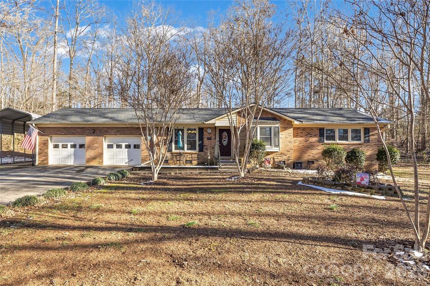 Full brick ranch on a generous .87-acre lot in York County, SC, adjacent to Spring Hill Golf course!  This well-maintained 3-bedroom, 2-bath home offers approximately 1,500 square feet of comfortable, single-level living with a thoughtful layout and timeless charm.

Step inside to find hardwood floors and a welcoming family room anchored by a cozy wood-burning fireplace—perfect for relaxing evenings or gathering with friends. The kitchen features stainless steel appliances, ample cabinetry, and easy flow into the dining area, making everyday living and entertaining effortless.

A spacious sunroom adds valuable flex space, ideal for a home office, reading room, or enjoying peaceful views of the expansive yard year-round. Bedrooms are well-sized, and the primary suite includes a private bath.

Outside, the nearly one-acre lot provides room to spread out, garden, or simply enjoy the privacy. Additional features include a two-car garage, attached carport, and solar panels for energy efficiency and long-term savings.

A rare combination of solid construction, usable land, and cozy character—this brick ranch offers comfort, functionality, and space to make it your own.  Roof replaced 2024, HVAC replaced 2025.