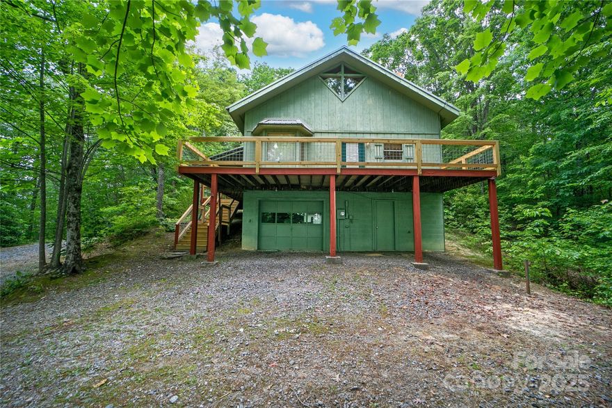 Welcome to 261 Franks Cove road in the private mountain community of Round Mountain. Enjoy winter views from your recently rebuilt deck or relax in the shade of your expansive covered side porch. Sitting along the mountainside, you will enjoy winter views, excellent sunsets, and multiple rock outcroppings that grant you the privacy and mountain aesthetic you desire. Upon entering, you will find a the true cabin charm of the mountains with wood ceilings, ample natural light, an open concept kitchen/dining area, a large primary bedroom w/direct access to the covered porch, and a main-level full bathroom. Up a storybook spiral staircase, you will find a large open bedroom with additional full bathroom, small balcony, and newly created flex space. Don't miss out on this excellent opportunity to own an income generating mountain retreat in beautiful Brevard, NC, where the fish are always biting and the trails are always calling.