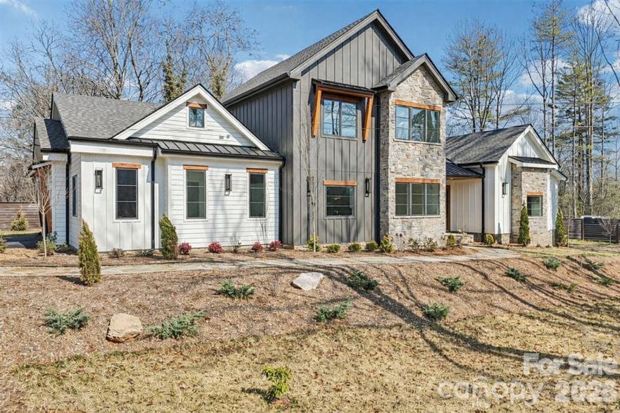 Introducing a remarkable custom residence thoughtfully designed and engineered to stand the test of time. Located less than one mile from the charm and vibrancy of Main Street Brevard, this newly constructed architectural home blends timeless craftsmanship, designer-curated interiors, and rare steel-frame construction into a property destined to be enjoyed for generations. Unlike conventional wood-framed homes, this residence is built using structural steel framing, providing exceptional strength, durability, and long-term stability. Steel construction offers superior resistance to warping, settling, moisture, pests, and fire while maintaining precise structural integrity over time. The result is a home that feels solid, quiet, and enduring—an investment in both luxury and longevity rarely found in residential construction. From the moment you arrive, the home makes a striking architectural impression. The exterior combines natural stone, modern mountain design elements, and warm textures that create a presence both sophisticated and inviting. Inside, the main living area opens to an expansive great room defined by soaring ceilings, exposed architectural beams, and a dramatic stone fireplace that anchors the space. Natural light fills the home through large windows that frame views of the surrounding landscape while creating a warm and welcoming atmosphere throughout the living spaces. Wide-plank hardwood floors, custom millwork, and carefully selected designer lighting contribute to an interior that feels both refined and comfortable. The chef’s kitchen is a true centerpiece of the home, thoughtfully designed for both everyday living and entertaining. Anchored by a generous center island, the space features premium cabinetry, elegant countertops, and high-end appliances. The open layout flows seamlessly between the kitchen, dining area, and great room, creating an ideal setting for gatherings both large and small. The main-level primary suite provides a private retreat designed with relaxation in mind. The spa-inspired bathroom features elegant finishes, a soaking tub, walk-in shower, and a spacious walk-in closet, creating a luxurious and peaceful sanctuary within the home. Additional bedrooms and flexible living spaces offer comfort and versatility for family members, guests, or home office needs. Outdoor living is equally impressive. A beautifully designed covered terrace with its own fireplace extends the living space outdoors, creating the perfect setting for year-round enjoyment. Whether entertaining guests or enjoying a quiet evening under the stars, the outdoor spaces feel like a natural extension of the home’s interior. One of the home’s most desirable features is its exceptional location. Situated less than a mile from downtown Brevard, owners enjoy easy access to the town’s beloved restaurants, art galleries, music venues, boutique shopping, and year-round festivals while still enjoying the privacy and comfort of a beautifully designed residential setting. With approximately 3,020 square feet of thoughtfully designed living space, this exceptional home offers the rare combination of architectural distinction, advanced structural construction, curated luxury finishes, and an unbeatable location. Opportunities to own a steel-framed custom home of this caliber in the heart of Brevard are extraordinarily rare. This is more than a home. It is a legacy residence built to endure for generations.