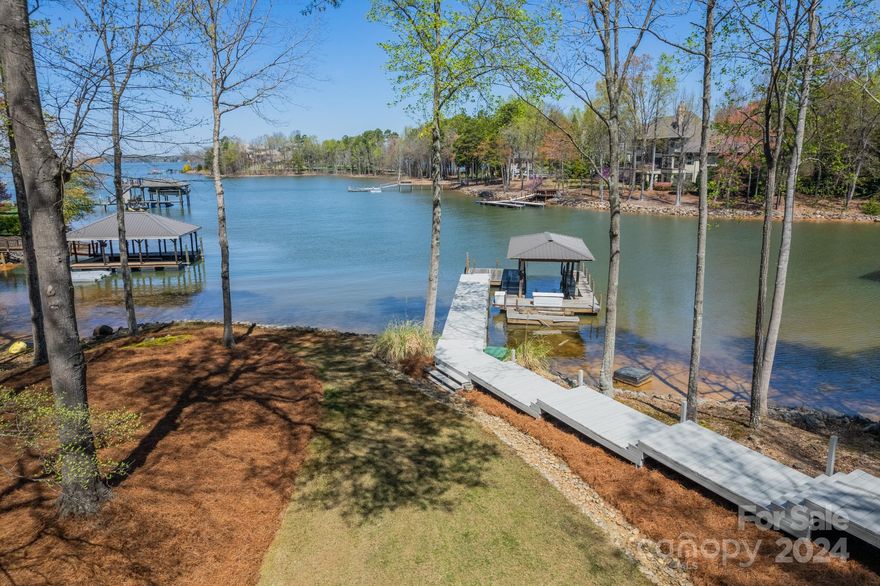 New Improved Price! Escape to this luxurious lakeside retreat on Lake Norman! Nestled on over 1.2 acres of pristine shoreline, this waterfront home offers over 3700 SQFT of renovated space WITHOUT HOA restrictions! Enjoy breathtaking long-range views from every window and unwind on the inviting back porch, perfect for alfresco dining or sunset lounging. The property features a covered boat dock for endless water adventures and ample room for a pool. Located on the sought-after Brawley Peninsula, near Trump National Charlotte, with optional membership benefits. Recent upgrades include new paint, hardwoods, lighting, carpet, roof, gutters, fixtures, and LVPlank flooring in the renovated basement. Experience the ultimate in lakeside living and make this your vacation getaway for everyday life!