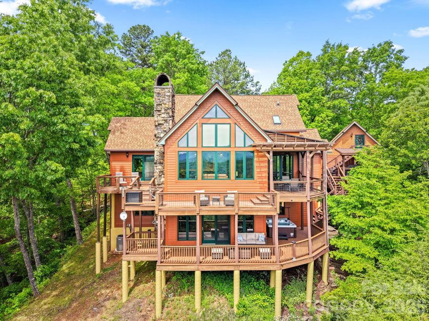 Perched in the sought-after community of Fontana Lake Estates in Bryson City, this beautifully updated lake-view home blends mountain charm with modern comfort. Designed to capture sweeping views of Fontana Lake and the surrounding Smoky Mountains, the property offers both serenity and convenience in one exceptional package.  Extensively upgraded, the home features a new 25-year roof on both the house and garage, complete with a 10-year transferable labor warranty. Inside, you’ll find fresh interior paint throughout, enhanced by new LED lighting, luxury vinyl flooring on the lower level, and a stunning rhododendron railing that adds authentic mountain character to the living room.  The kitchen has been thoughtfully modernized with a new granite countertop, updated sink with Moen faucet, and a new KitchenAid dishwasher. Relaxation comes easy with a new Fyre gas log set, a four-seat Master Spa hot tub, and Trex decking on both levels—perfect for enjoying the incredible lake views year-round. Comfort and efficiency are top priorities with a new 100,000 BTU Trane two-speed furnace paired with a Wi-Fi-enabled thermostat, as well as a new pressure tank and switch for the water system. Accessibility is enhanced by a newly installed two-passenger Stultz elevator.  Additional highlights include a fully insulated and drywalled garage, a heated and finished bonus room above, a custom bar with bar back hutch in the lower level, a motorized skylight shade in the guest bath, and a transferable Starlink internet system for reliable connectivity.  This turnkey mountain retreat offers the perfect blend of luxury, practicality, and breathtaking natural beauty—ready for you to enjoy from day one.